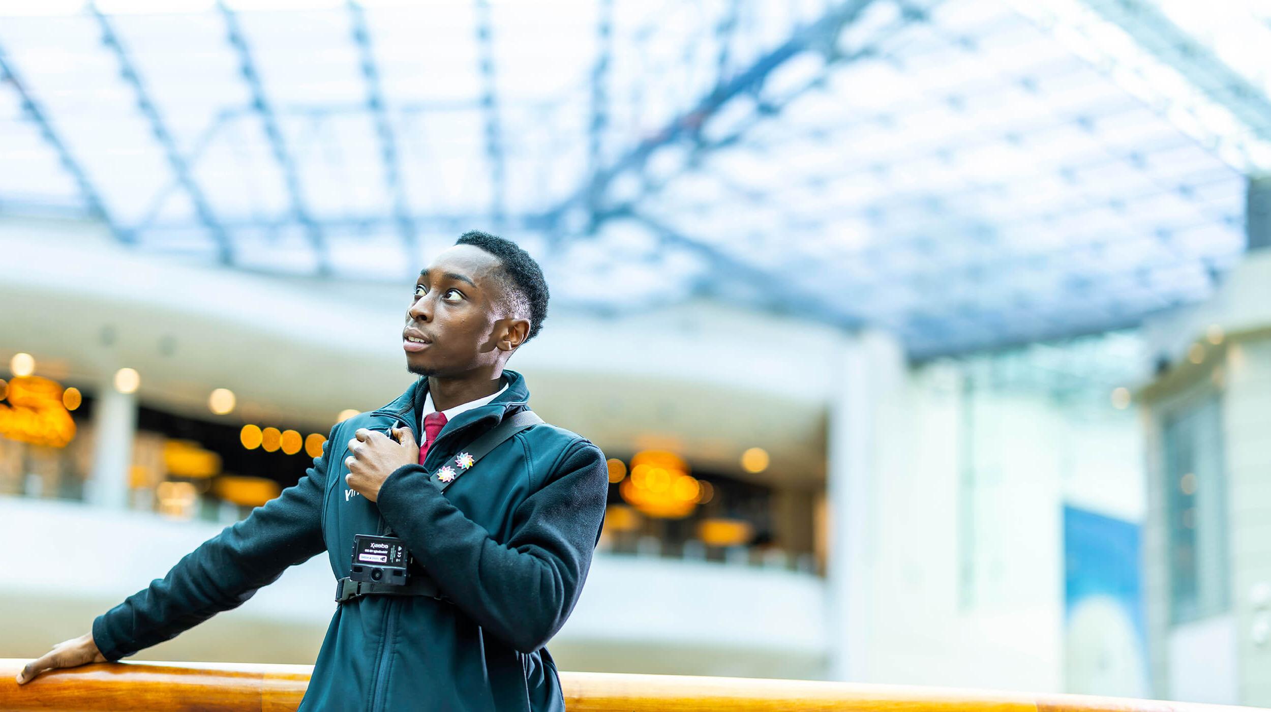 A Mitie black male security guard in a shopping centre